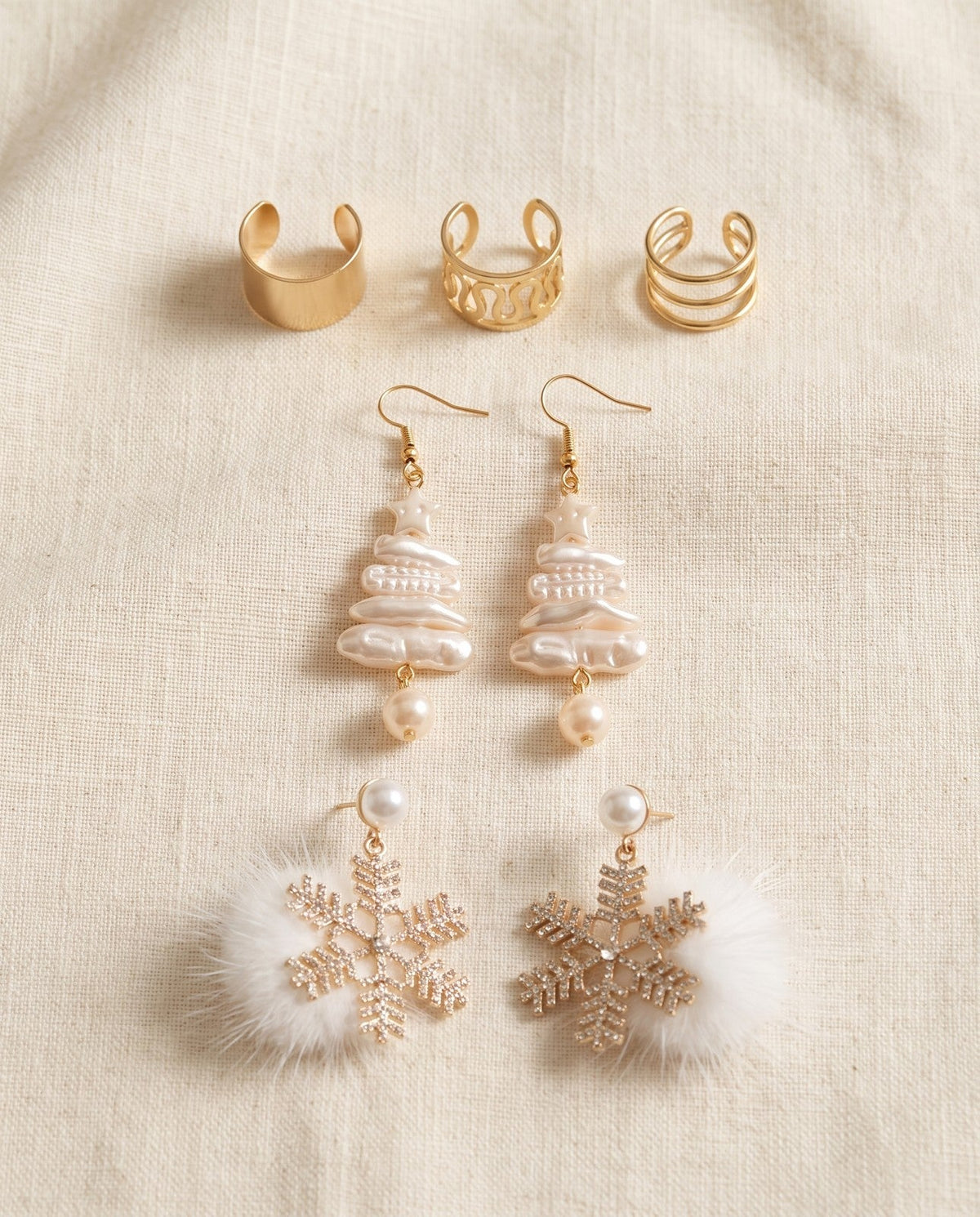 Free earrings on ivory linen: the Huggie set, ear cuffs and Christmas earrings