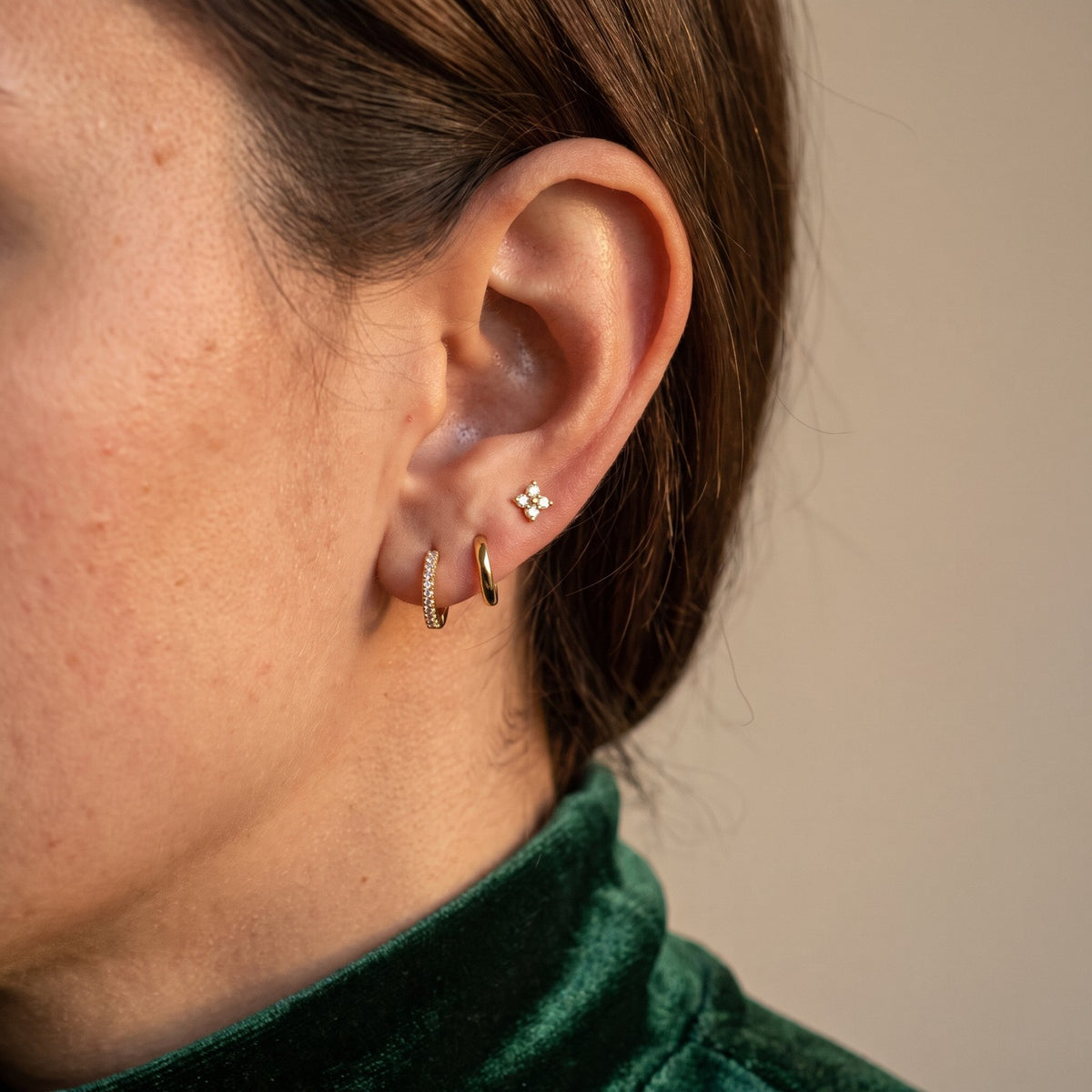 Gold tone earring set worn with a green velvet top