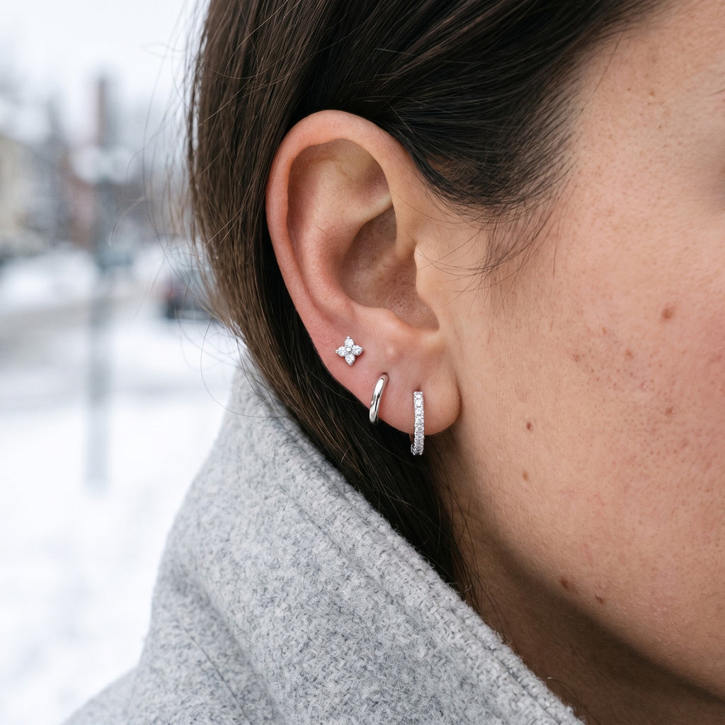 Silver tone earring set worn in one ear