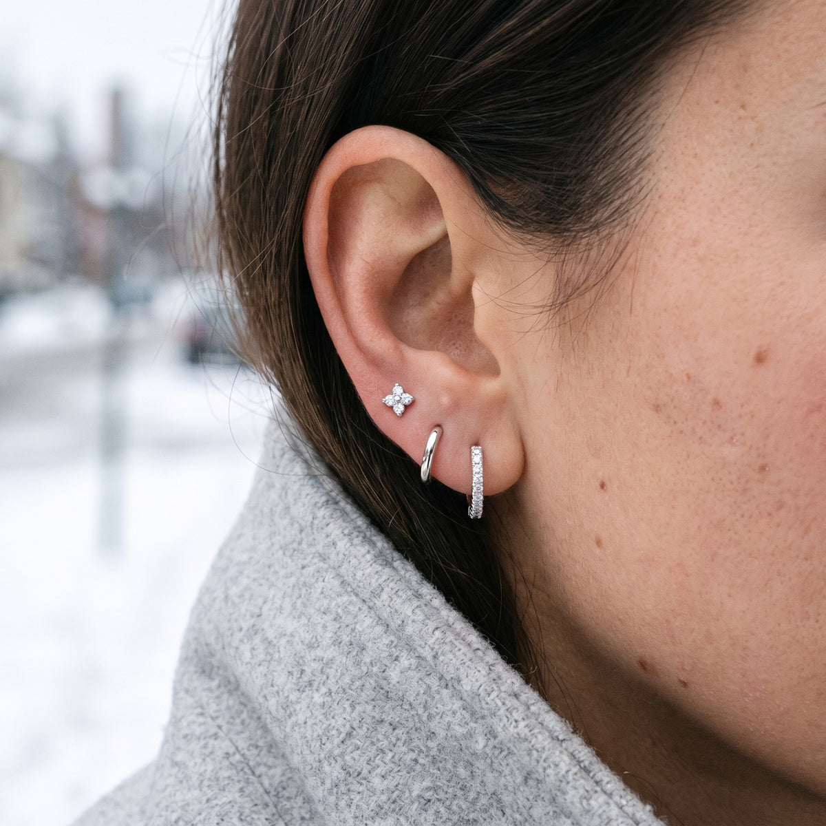 Silver tone earring set worn in one ear