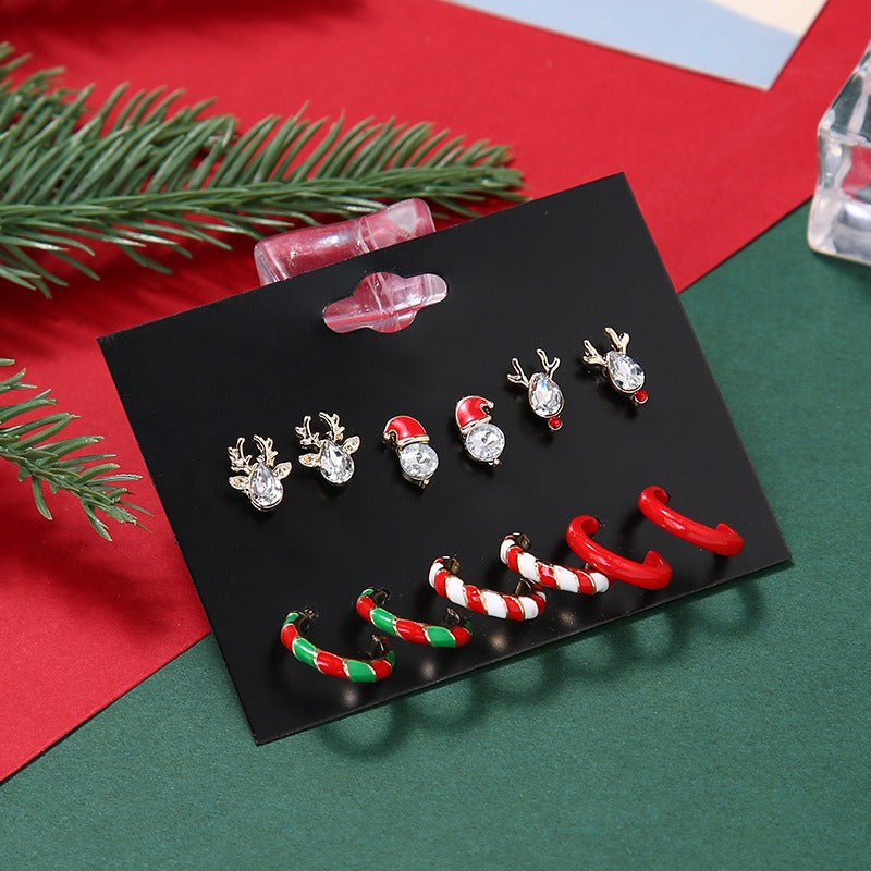 Six pairs of Christmas earrings on a card: reindeer and Santa studs and striped hoops