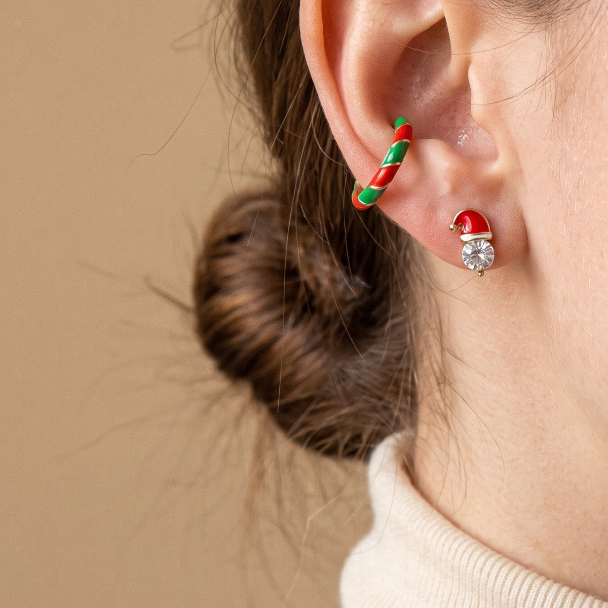 A Santa hat stud and a green and white striped hoop from the Christmas set, worn