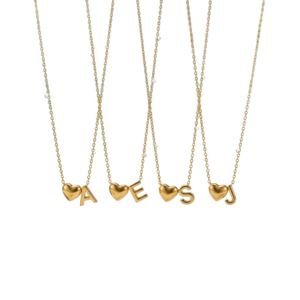 Four initial necklaces, each with a small heart beside a capital letter