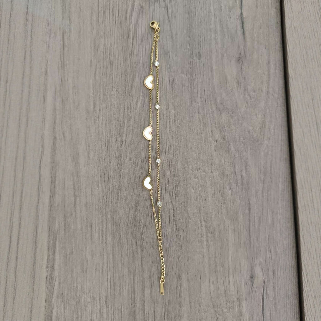 Gold tone two strand heart bracelet laid flat