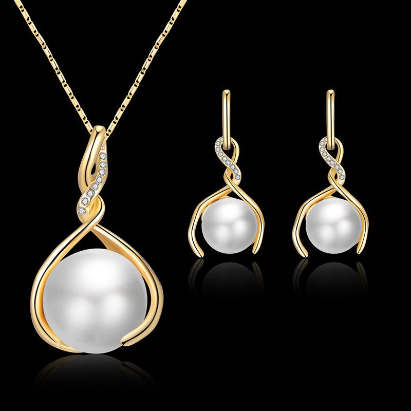 Gold tone necklace and earrings, each a twist holding a faux pearl bead