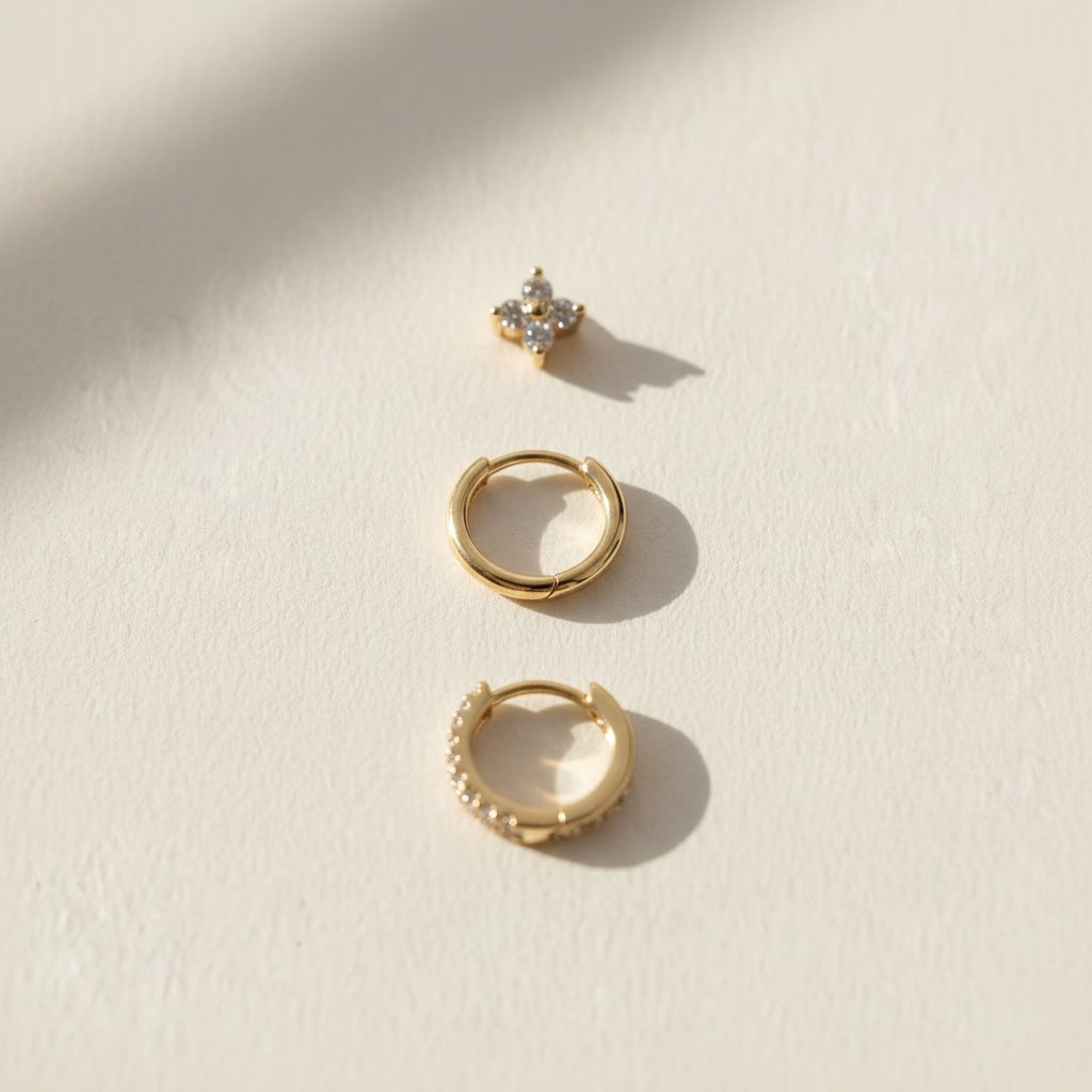 Close up of the three Huggie earrings in gold tone