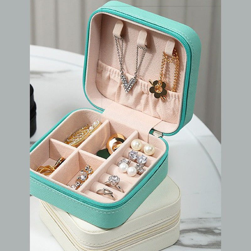 The light blue travel jewelry case open, with the pearl white case closed below it